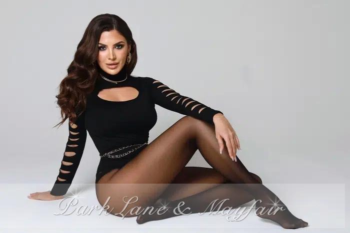 A distinguished escort showcasing her long, flowing hair and captivating features.